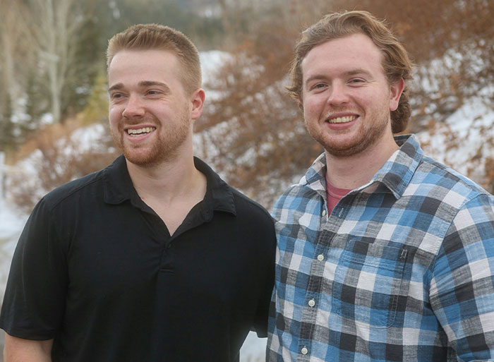 Two men standing outdoors, smiling, with trees and snow in the background, illustrating unexpected family secrets from online DNA tests.