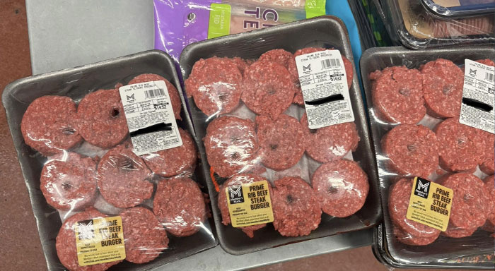 Grocery display of packaged beef burgers, highlighting customer cluelessness in shopping choices.