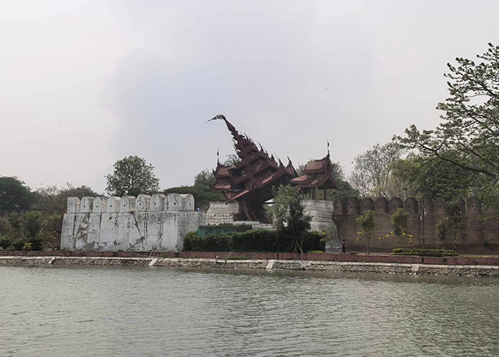Scenic view of Myanmar temple by the river, showcasing traditional architecture amidst a peaceful landscape.