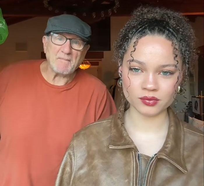 Ed O'Neill standing with his daughter, both looking at the camera in a casual home setting.