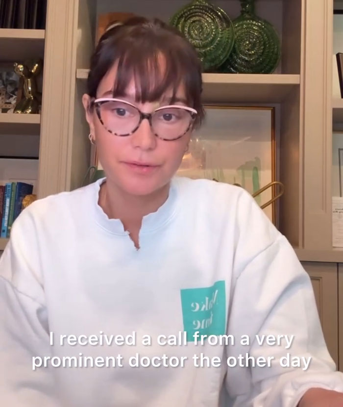 Woman in glasses shares news about actor's dementia diagnosis in a home setting. Woman in glasses shares news about actor's dementia diagnosis in a home setting.