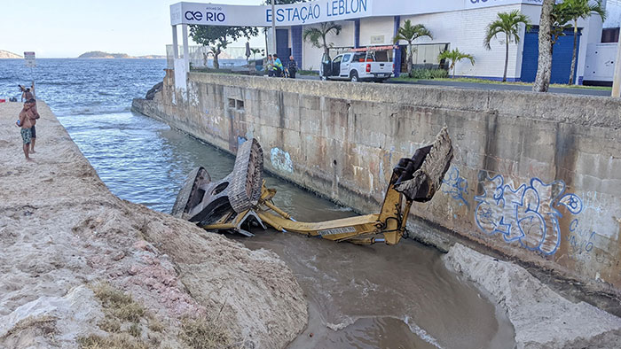 Construction vehicle in ditch by ocean, representing a worker's worst day at work.