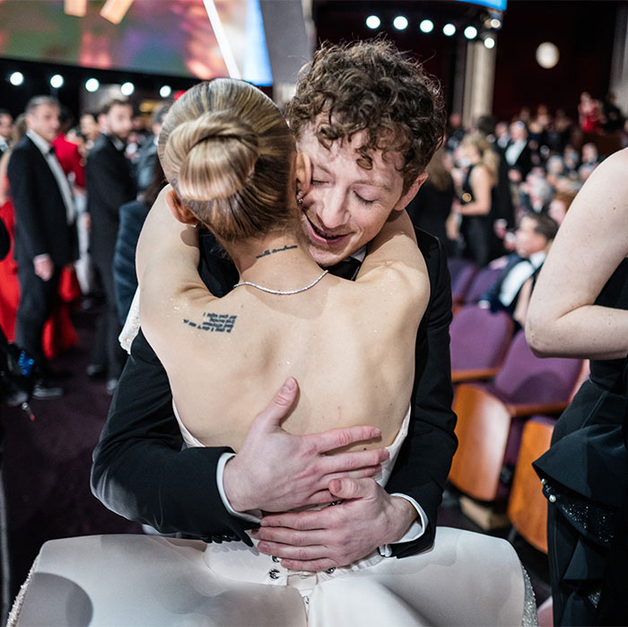 Two people share an emotional hug at the Oscars 2025, capturing an unnoticed behind-the-scenes moment.