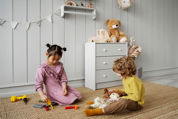 Children playing with toys in a cozy room, highlighting challenges of stepmom seeking bigger role in family dynamics.
