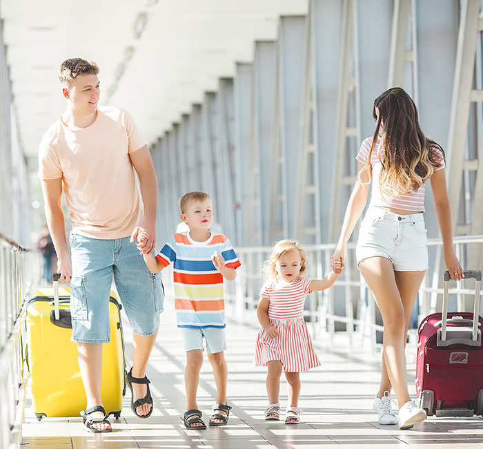 Family vacation scene in a bright airport with parents and two kids, highlighting family-first values.