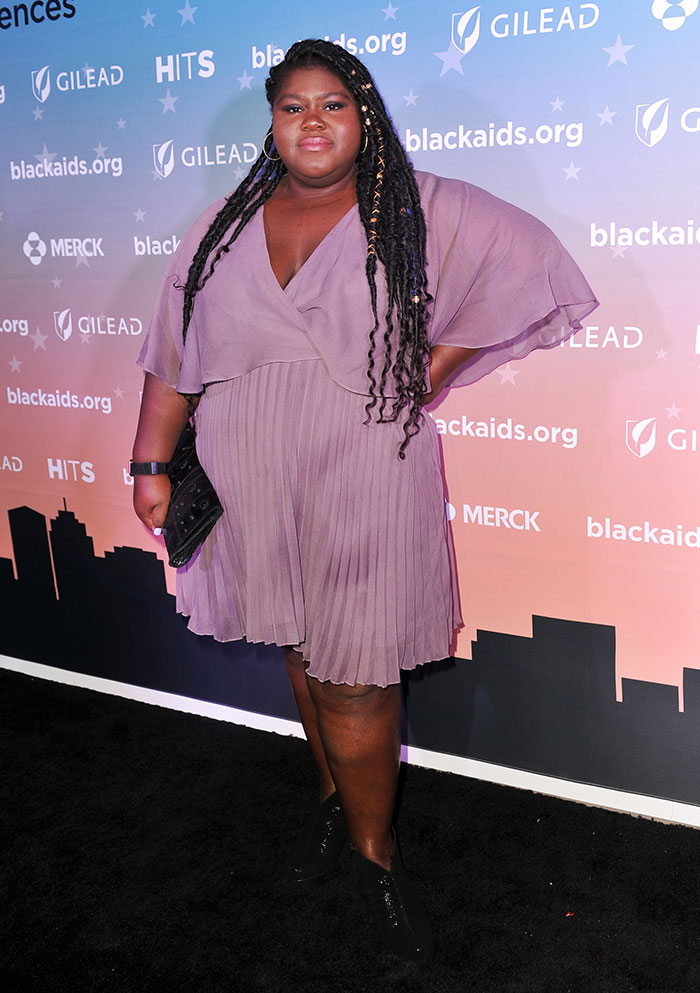 Celebrity woman poses confidently in a purple dress at a charity event, highlighting issues of weight and age in fashion.