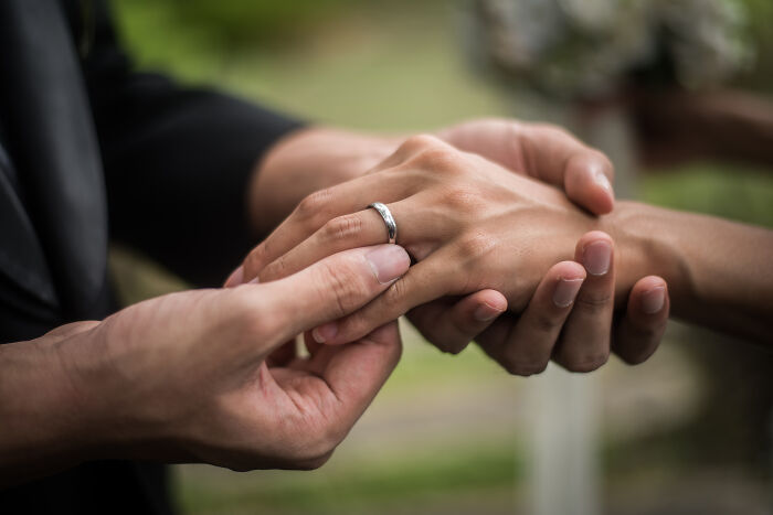Close-up of a woman's hand with an engagement ring, highlighting relationship issues.
