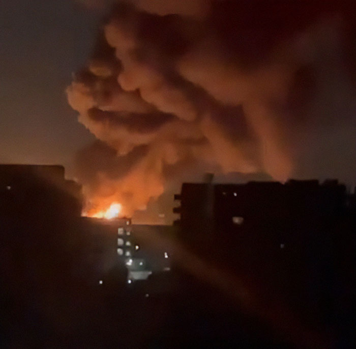 Dark skyline with smoke cloud and fire, chaos impacts Heathrow flights.