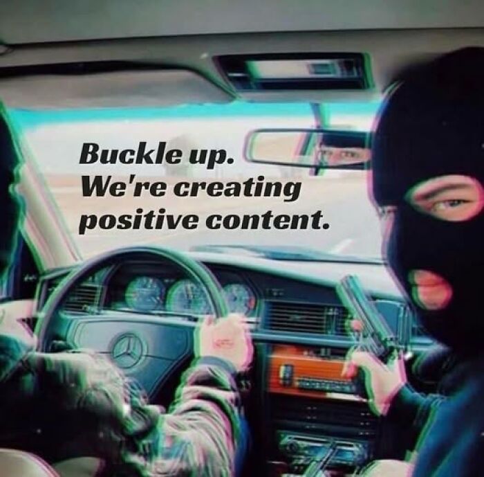 Two masked people in a car with the text "Buckle up. We're creating positive content." Dark humor mental health meme.