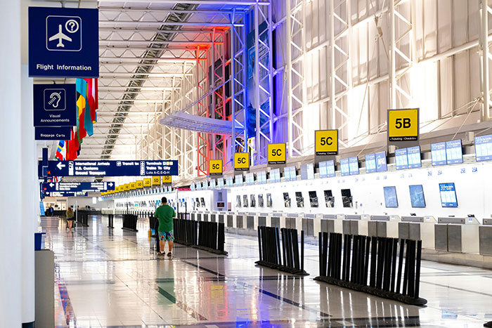 Empty airport terminal with colorful ceiling lights, reflecting travel freedom.