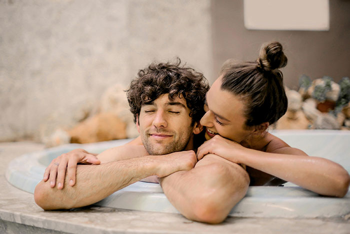 Child-free woman enjoying vacation in a hot tub, smiling and relaxed, showcasing leisure and freedom.