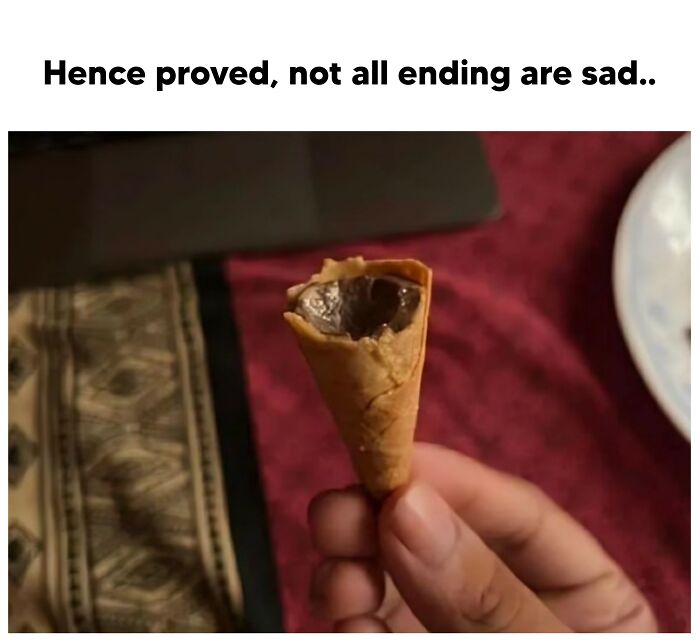 Chocolate-filled ice cream cone held in hand, with humorous text about happy endings above.