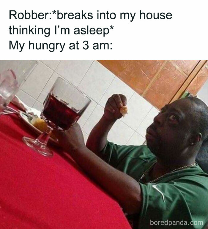 Man eating at 3 a.m. with a glass of wine on a red tablecloth, embodying late-night food cravings humor.