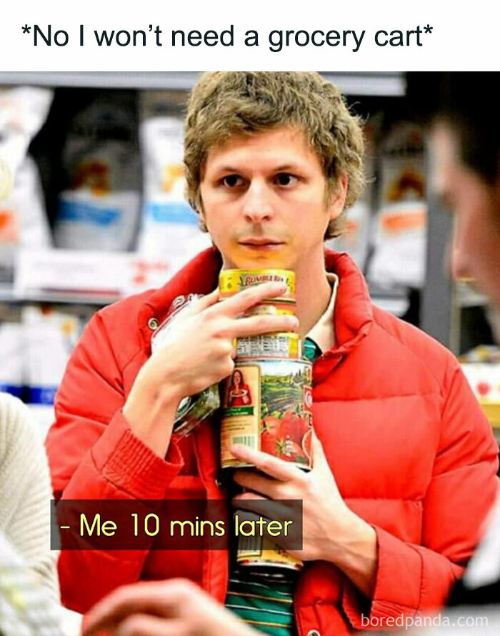 Person in a store holding multiple food items, humorously regretting not using a grocery cart, reflecting food meme.