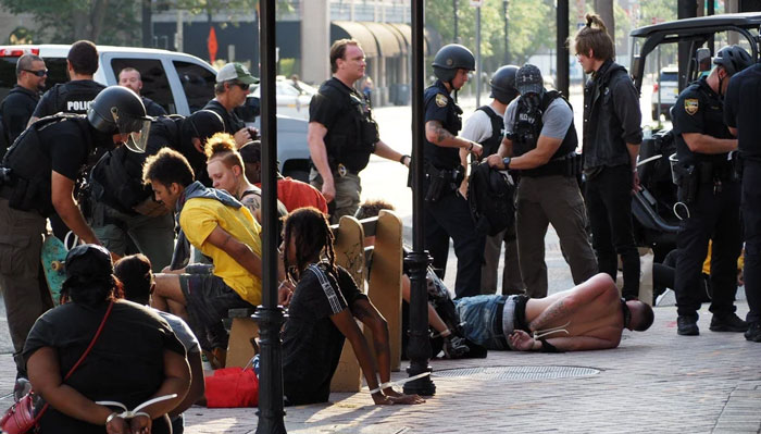 Police officers detaining several people on a busy street, relating to Florida man incidents.