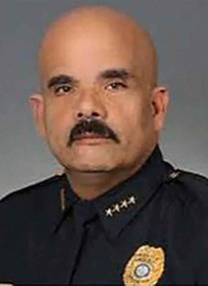 Bald man in police uniform with stars on collar and badge, related to Florida Man headlines.