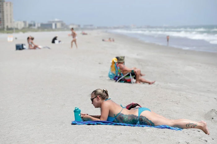 Beachgoers relaxing on a sunny Florida beach, showcasing a typical day enjoyed by locals and tourists alike.