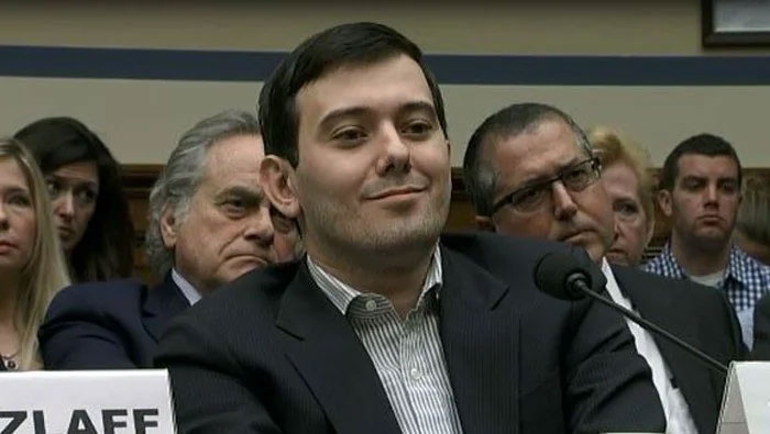 A person at a hearing, smiling slightly, surrounded by others, illustrating a Florida Man headline discussion.