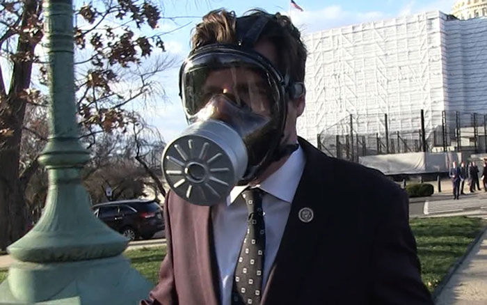 Man in a suit wearing a gas mask on a city street, capturing a bizarre Florida man moment.