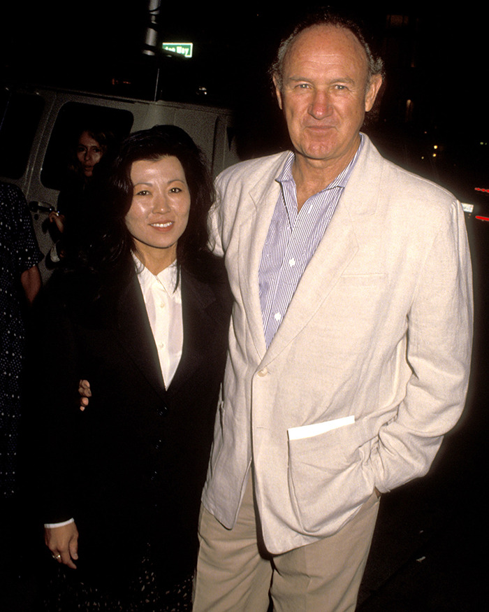 Man in a light suit and woman in a black jacket smiling, related to Gene Hackman timeline retraction. Man in a light suit and woman in a black jacket smiling, related to Gene Hackman timeline retraction.