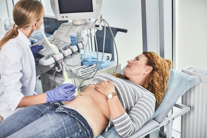 Woman receiving an ultrasound from a medical professional, showcasing a procedure that gets more criticism than deserved.