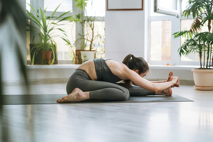Woman in yoga pose on mat, showcasing misunderstood healthy activity indoors.