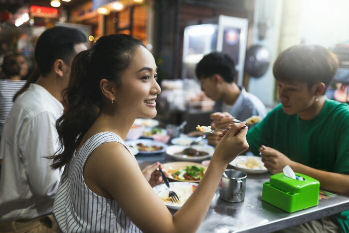 People dining at a vibrant food market, discussing their lifetime supply experiences.