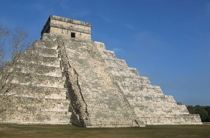 Ancient pyramid under a clear blue sky, representing historical structures from the dark side of history.