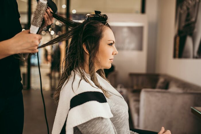 Woman getting hair styled, preparing for a wedding, as a part of stories about weddings gone wrong shared online.