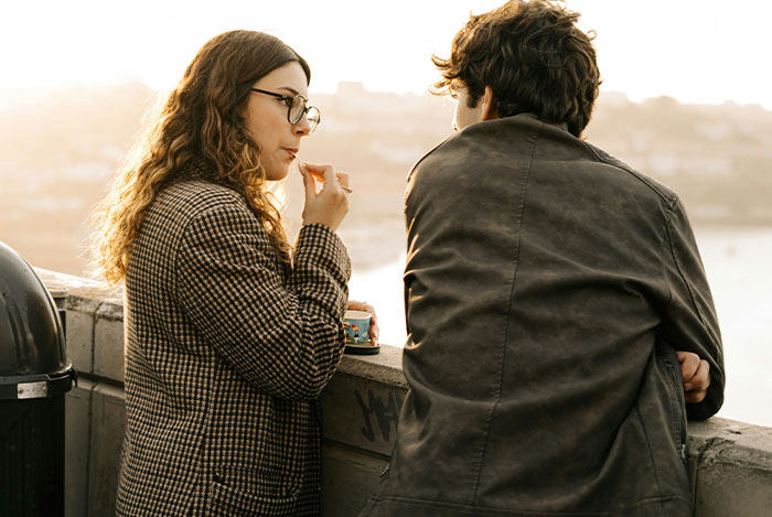 A woman and a man conversing on a rooftop, highlighting the complexities of giving "nice guys" a chance.