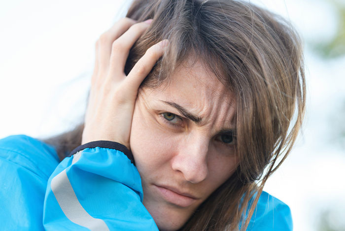 Woman in a blue jacket looks distressed, representing experiences with "nice guys."