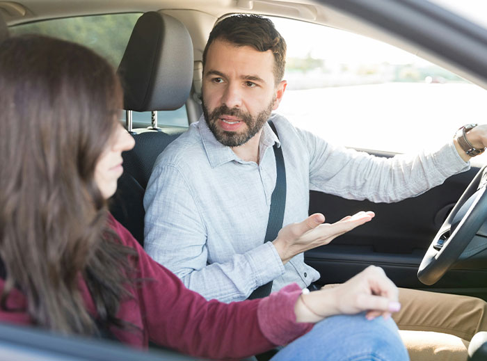 Man and woman in a car having an intense conversation, illustrating a creepy story involving a "nice guy."