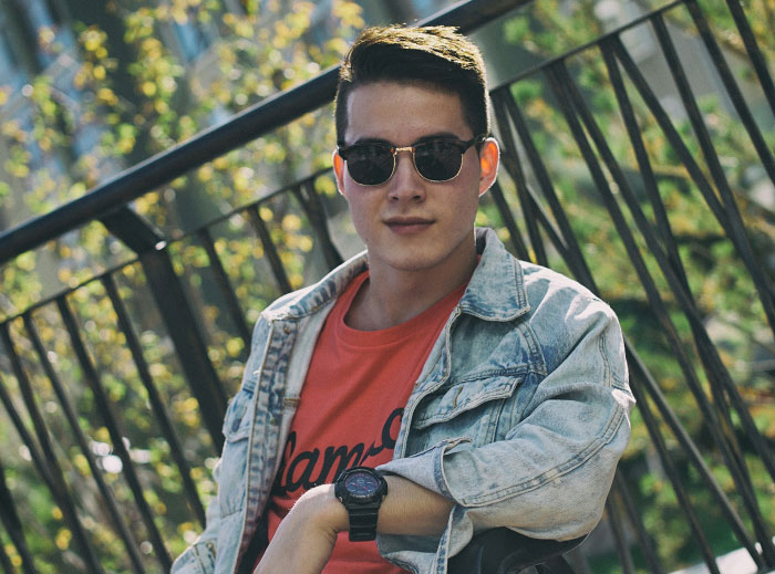 Young man in sunglasses and denim jacket outdoors, embodying the "nice guy" vibe.
