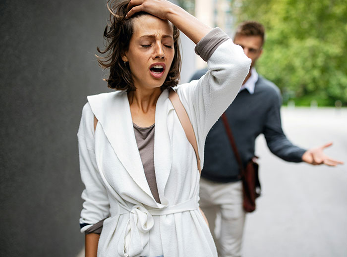 Woman looking distressed while man gestures behind her, illustrating a "nice guy" story moment.
