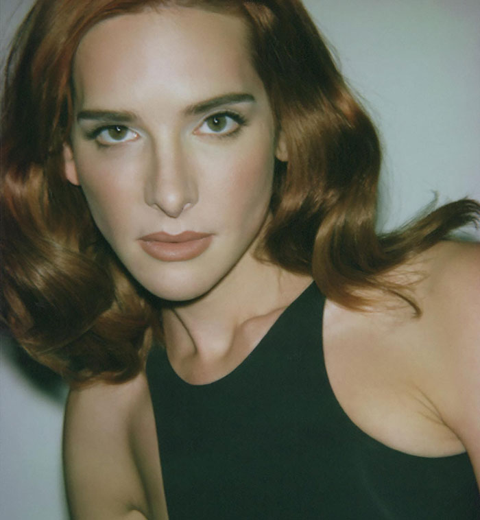 Transgender actor in a black top with red hair, showcasing influence in the movie industry.