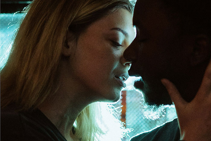 Two people close together in dim lighting, depicting a moment more than just friends.