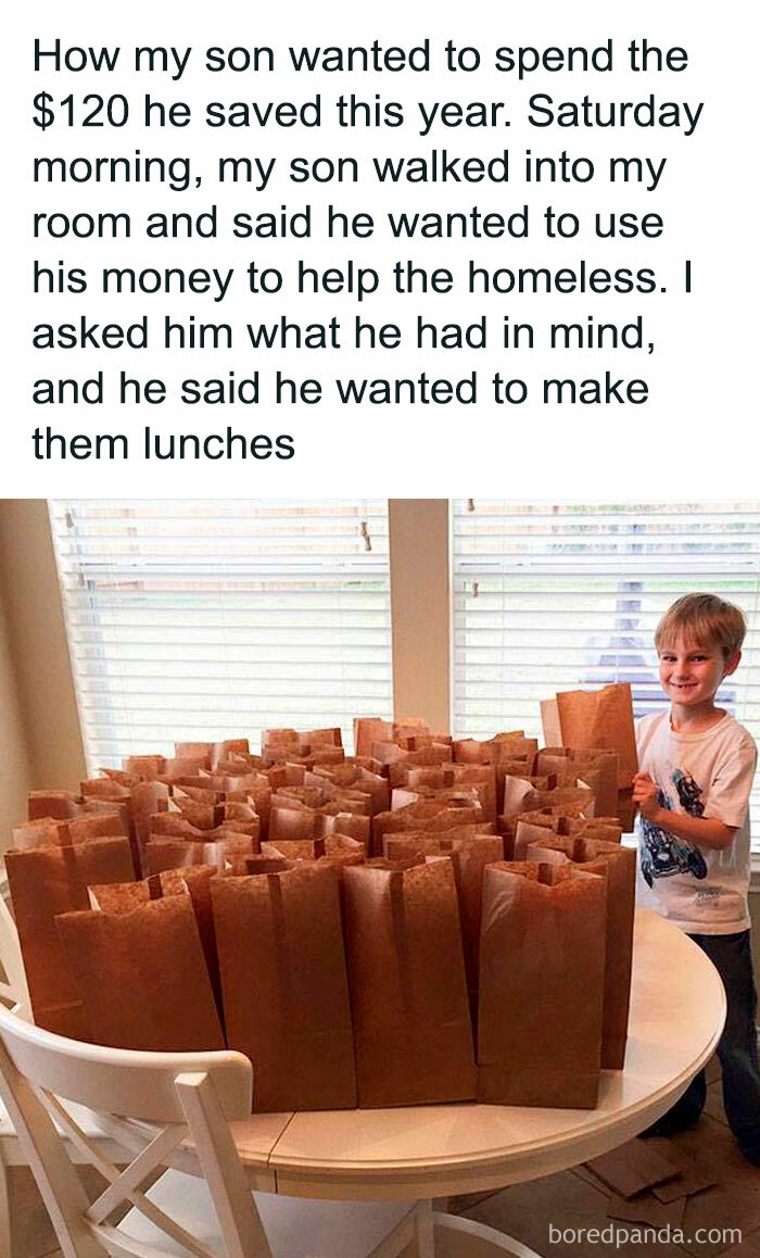 Young boy with paper bags filled with lunches for the homeless on a white table, spreading positivity and uplifting kindness.