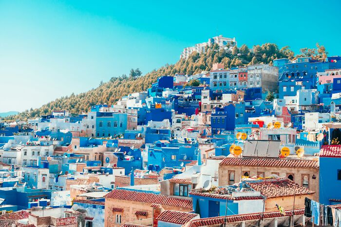 Blue-painted buildings in a touristy area suggested as overhyped by seasoned travelers.