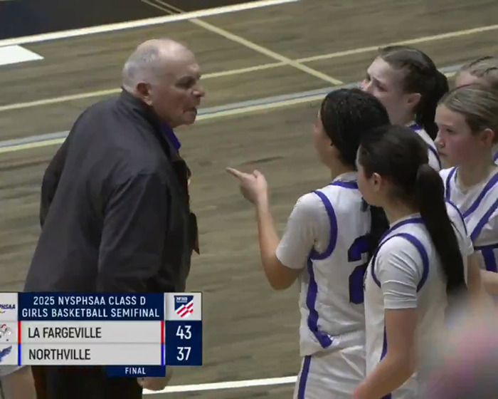 Basketball coach and players in intense discussion during a game.