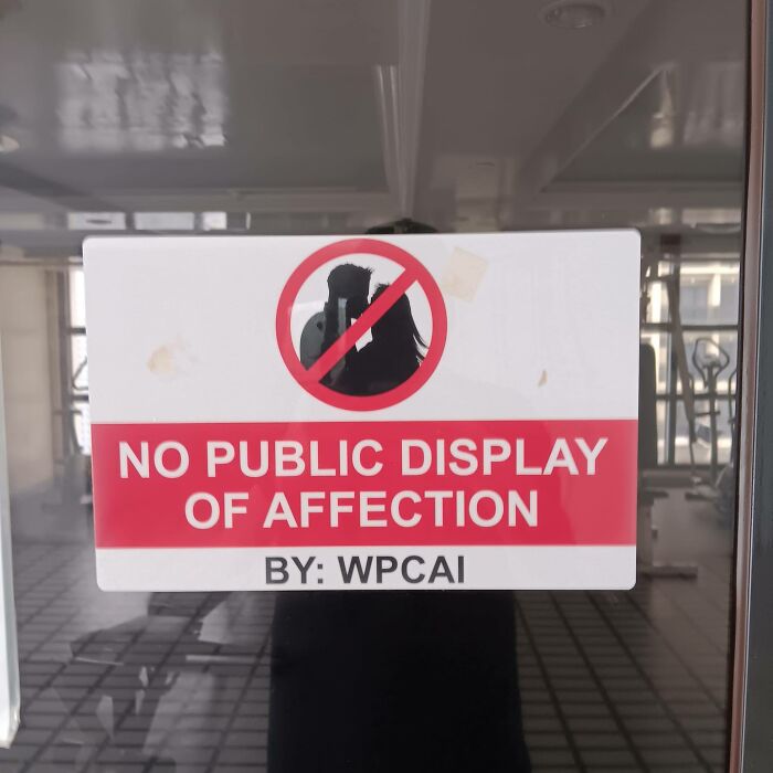 "Warning sign: No public display of affection allowed in the area."