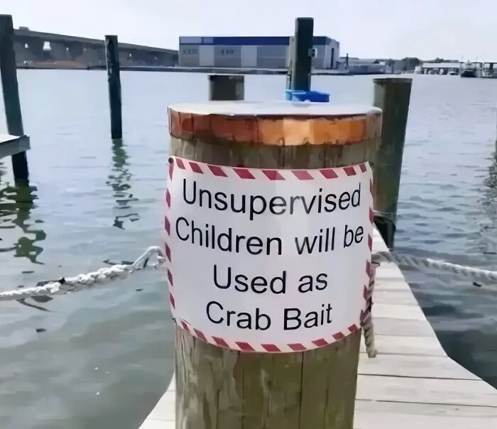 Sign warning about unsupervised children used as crab bait on a dock.