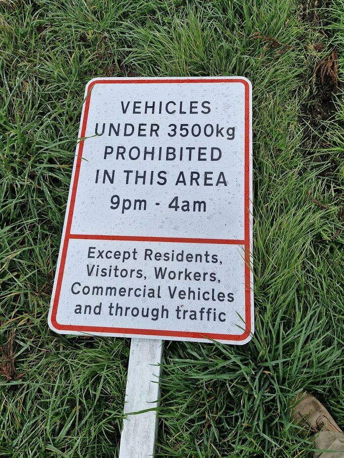 Warning sign prohibiting vehicles under 3500kg, lying on grass.