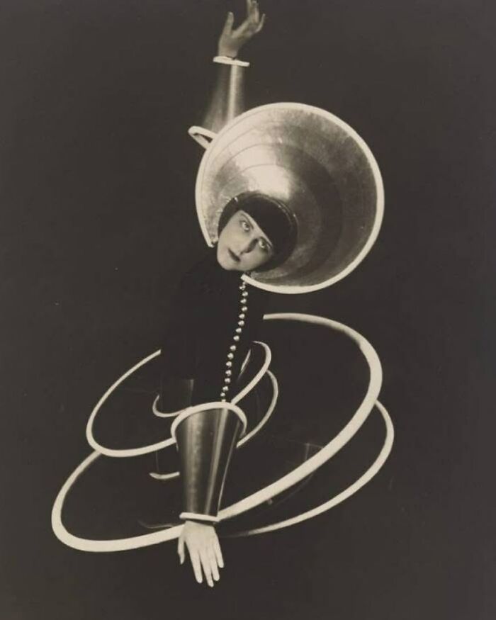 Dancer in avant-garde costume with metallic circles from forgotten corners of history.