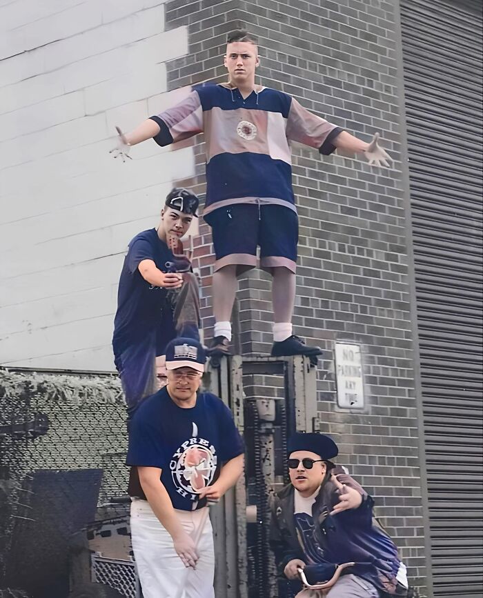 Group of people at an industrial site, showcasing forgotten corners of history with retro fashion and poses.