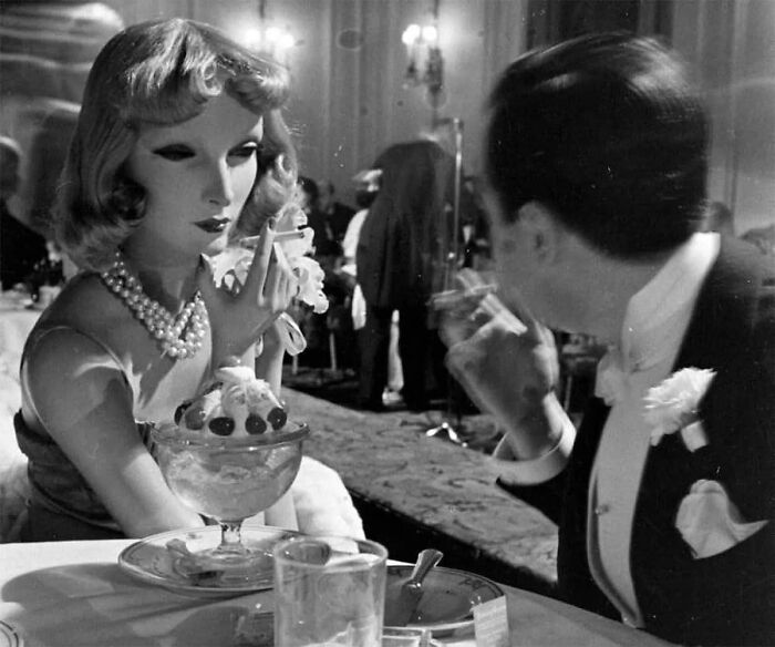 Vintage scene with a woman and man dining, showcasing a forgotten corner of history.