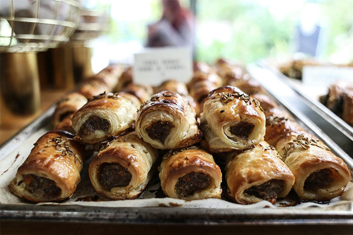Baked pastries arranged on a tray, featuring flaky crusts and seasoned meat filling, displayed in a cozy dining setting.