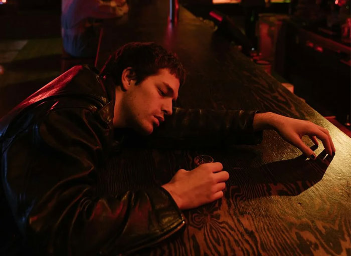 Man with a leather jacket asleep at a bar counter, exemplifying a creepy dating encounter.