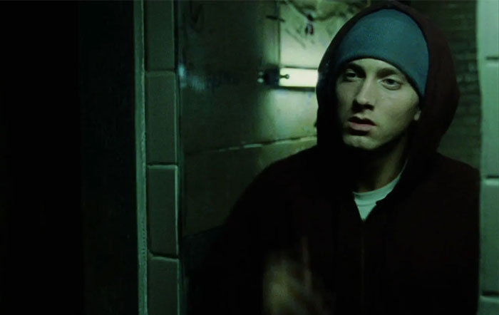 A person in a hoodie and beanie looks tensely in a dimly lit corridor, capturing an eerie dating moment.