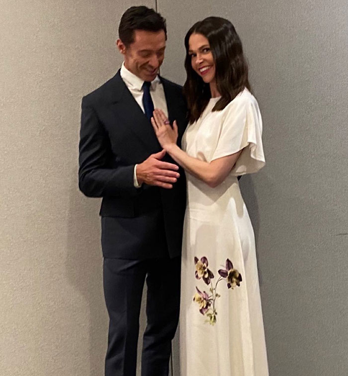 Couple dressed formally, smiling in a gently lit room, symbolizing unity amidst divorce challenges.