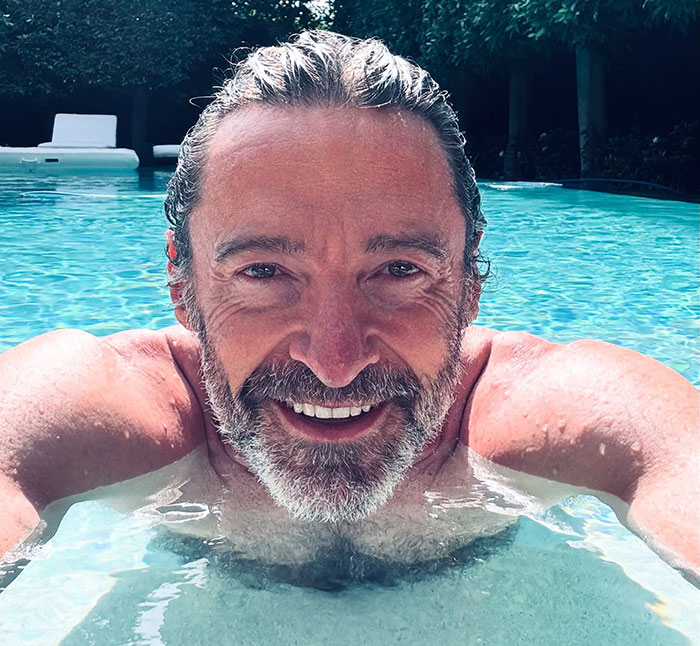 Man smiling in a pool with a rugged beard, capturing a laid-back vibe from the 70s Pawn Star era.